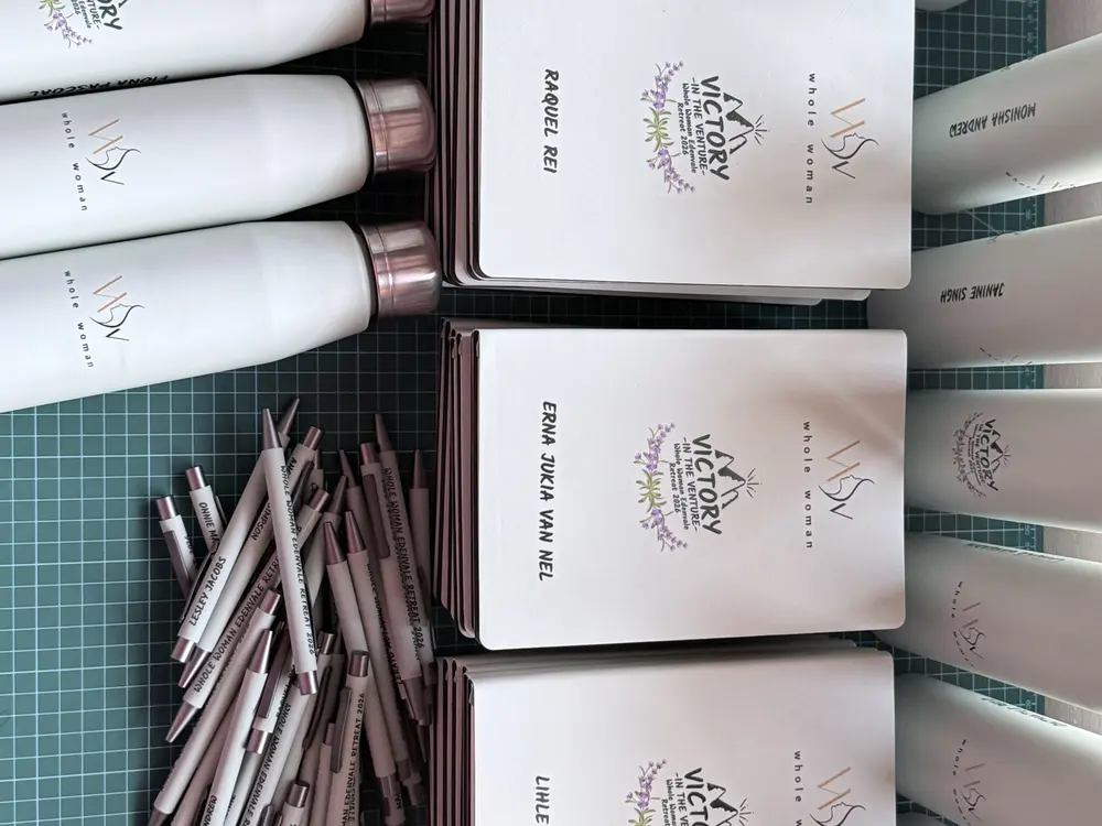 Branded bottles, notebooks and pens laid out ready to pack