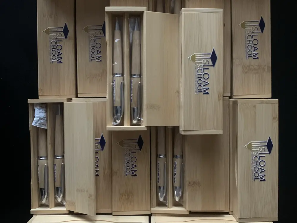Engraved bamboo gift boxes with pens, branded with a school logo